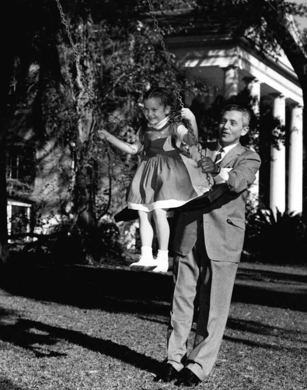LeRoy Collins pushing his youngest daughter Darby on a swing, January 1957.
