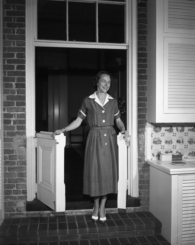 Mary Call Collins standing in a doorway dividing the original house from the new addition, 1957. Photo courtesy of the State Archives of Florida.